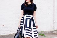 a monochromatic look with a black tee, a printed A-line skirt, red shoes and a black bag for work