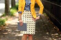 a grey bow shirt, a printed knee skirt, a sunyn yellow blazer, black lace up shoes and a printed clutch