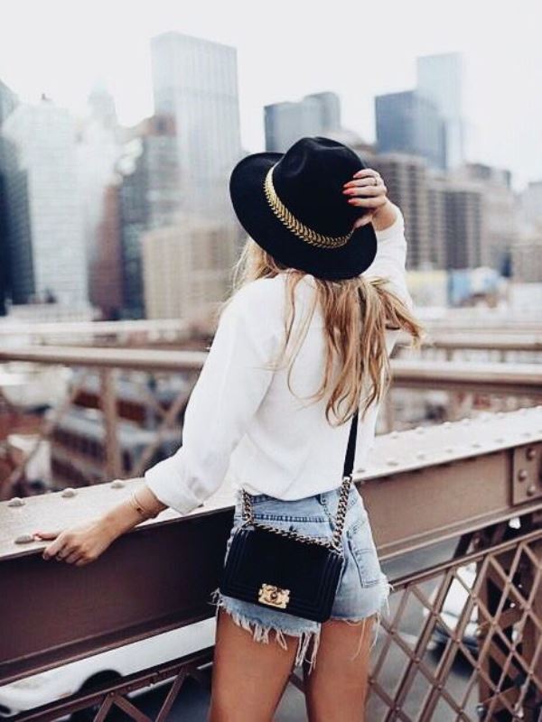 Raw Hem Jean Shorts With A White Blouse And Fedora Hat