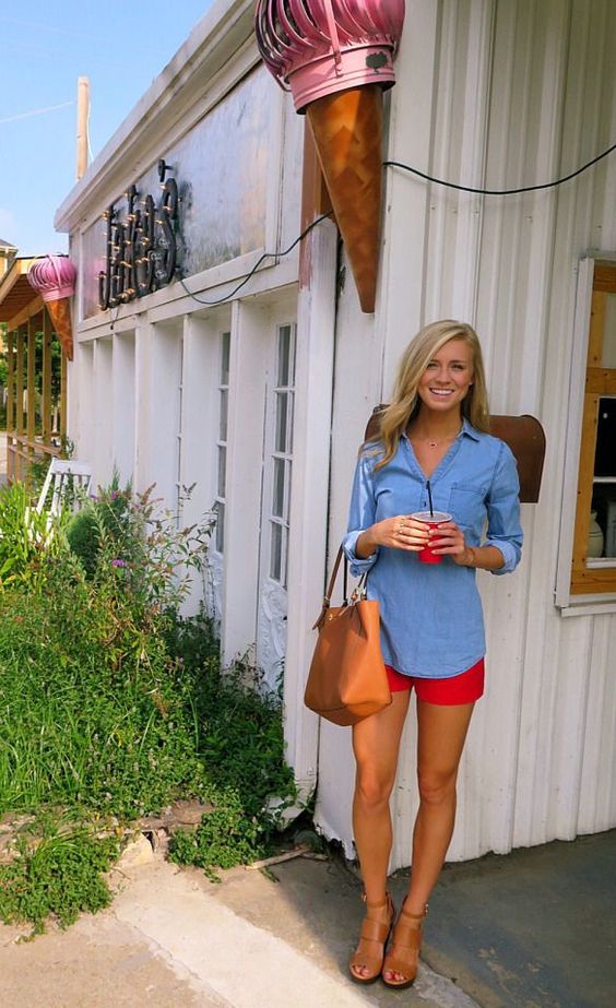 denim shirt and red shorts with tan shoes and purse