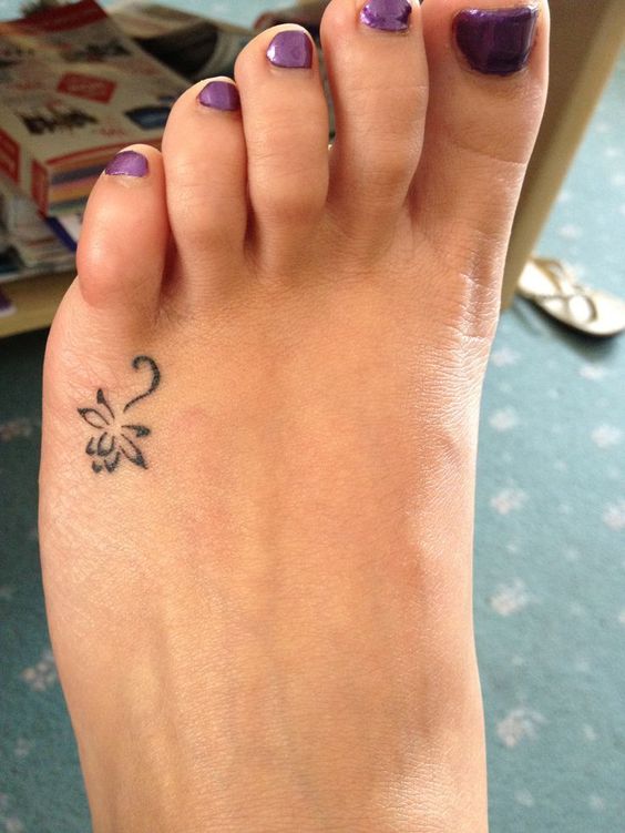 tiny flower foot tattoo