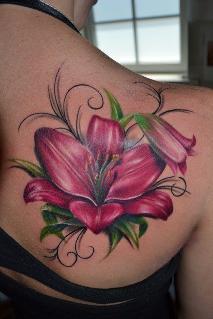 bold pink lily tattoo on the back