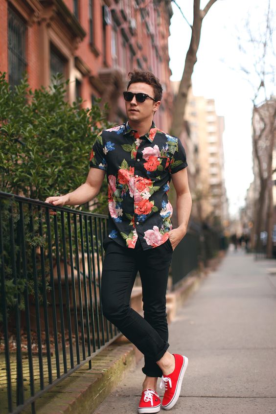 black jeans, a floral shirt and red sneakers
