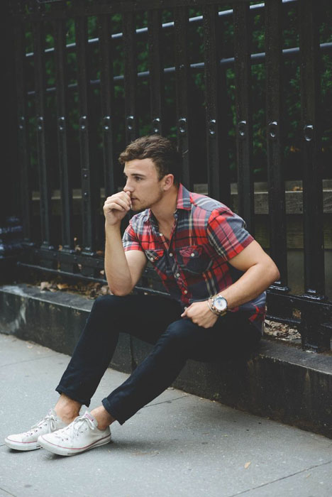 navy jeans, a checked short-sleeve shirt and white Converse