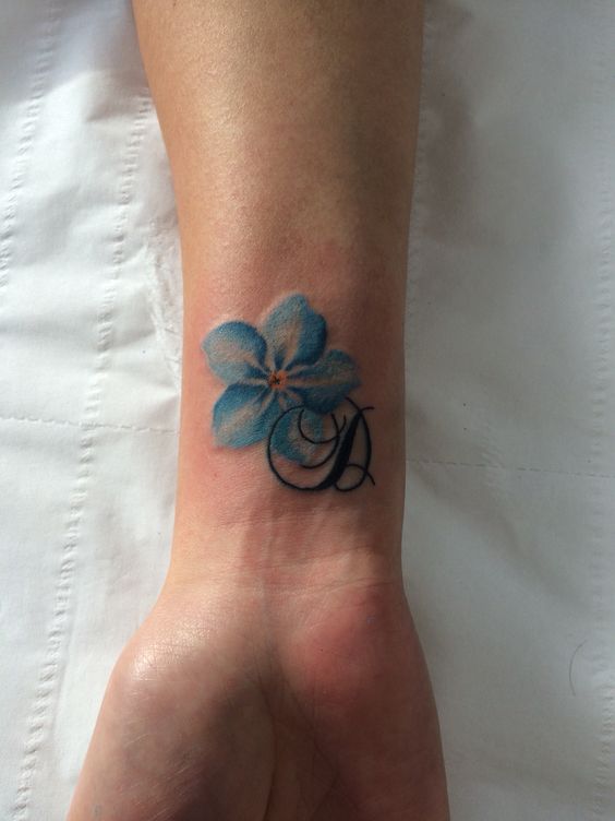forget-me-not wrist tattoo with a monogram
