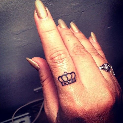 two small crown finger tattoos on one hand
