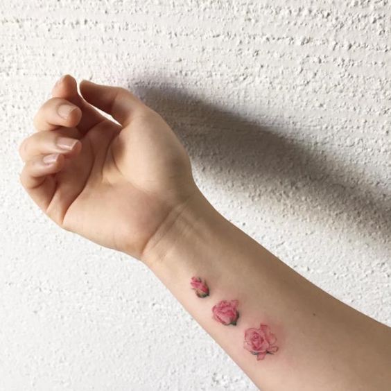 three suble pink flowers on an arm