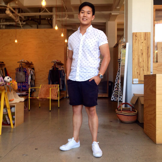 white sneakers, navy shorts and a printed shirt