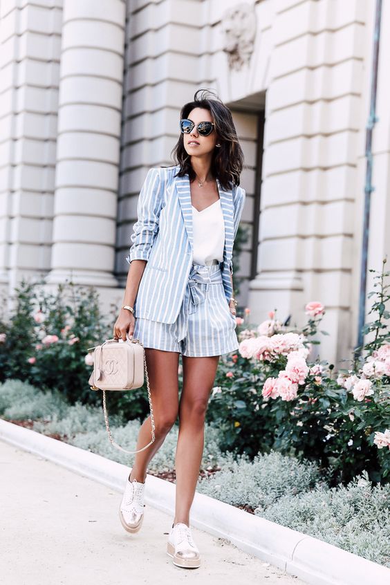 striped shorts, a striped jacket and white sneakers