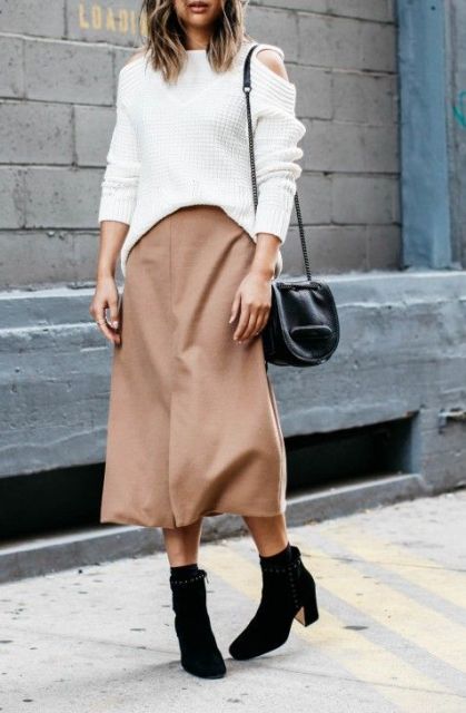 With white loose sweatshirt, mini bag and boots