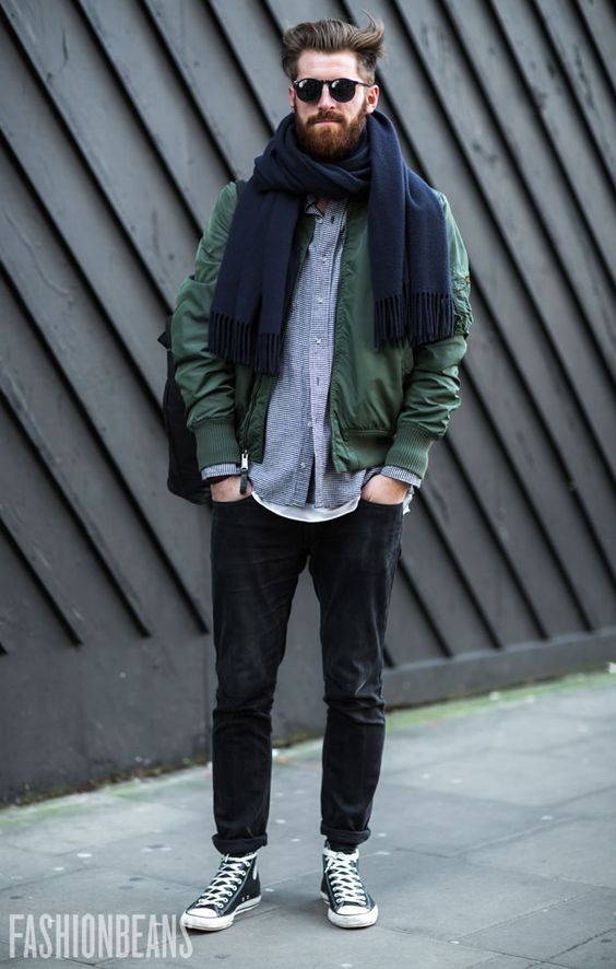 black jeans, a grey overshirt, an olive green jacket and a navy scarf
