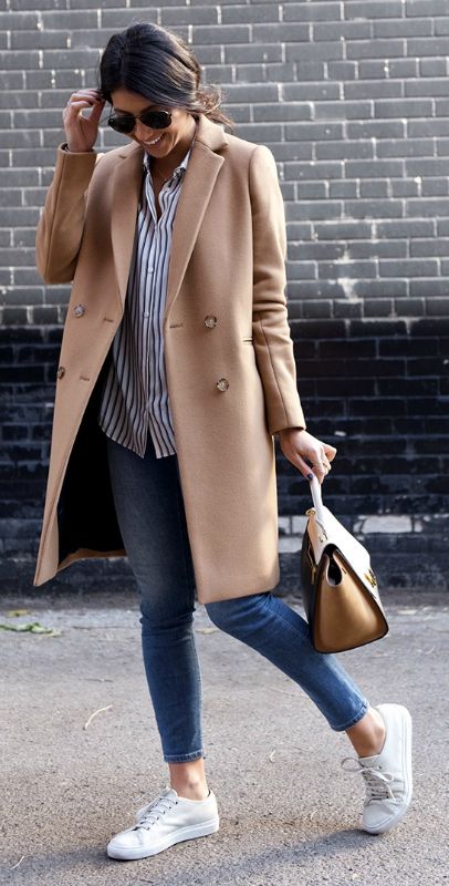 blue cropped jeans, a striped shirt, white sneakers and a camel coat