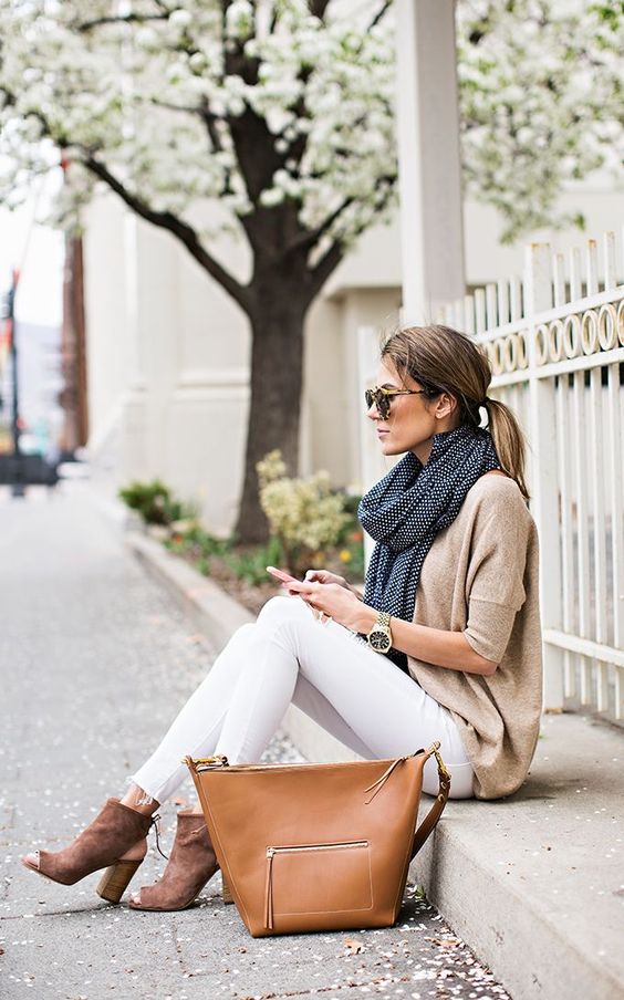 white jeans, a neutral sweater, cutout booties and a scarf