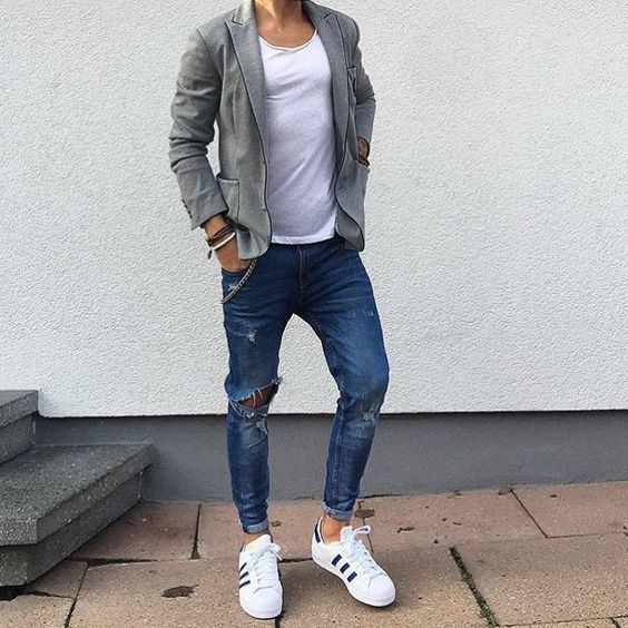 ripped blue jeans, white chucks, a white tee and a grey jacket