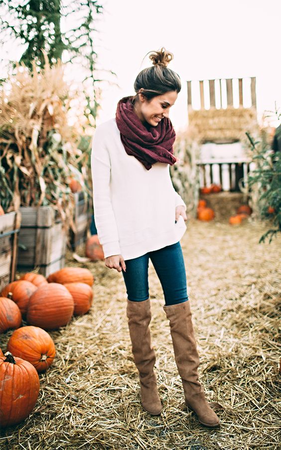 white sweater, blue jeans, a burgundy scarf and brown high boots
