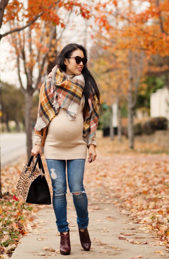ripped jeans, a tan sweater, ankle burgundy boots and a blanket scarf