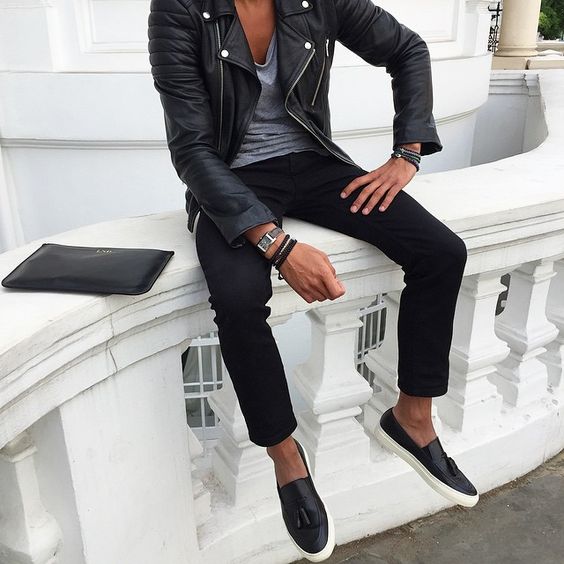 black trousers, a grey t-shirt, a black leather jacket and slip-ons