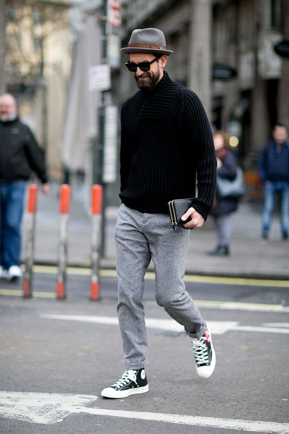 grey trousers, a chunky knit black sweater, black Converse