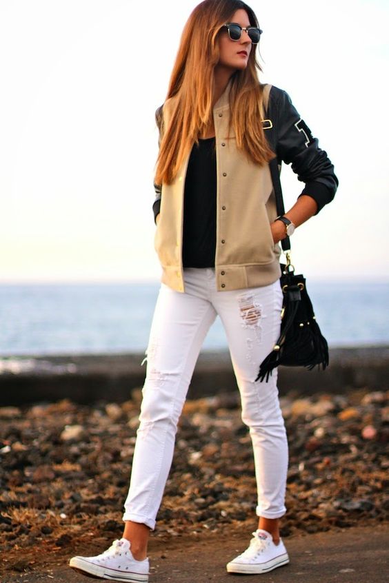 white ripped jeans, a black tee, a black and tan jacket
