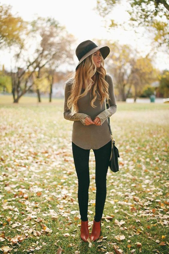 black leggings, a grey shirt, ankle boots and a hat