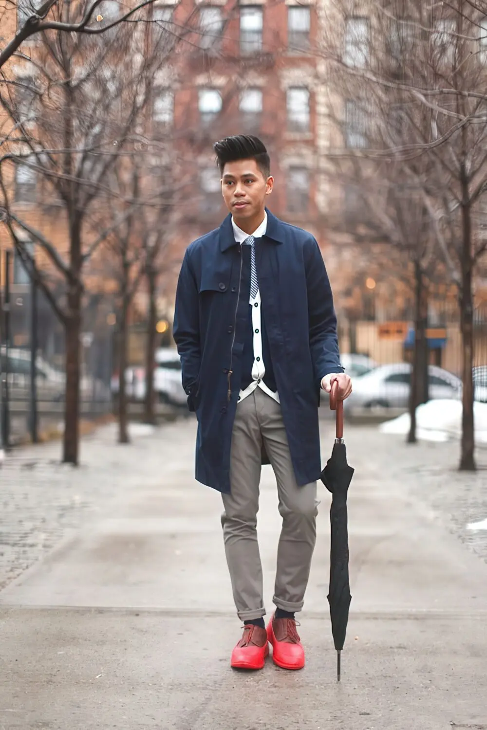 Grey pants, a navy rain coat and red boots