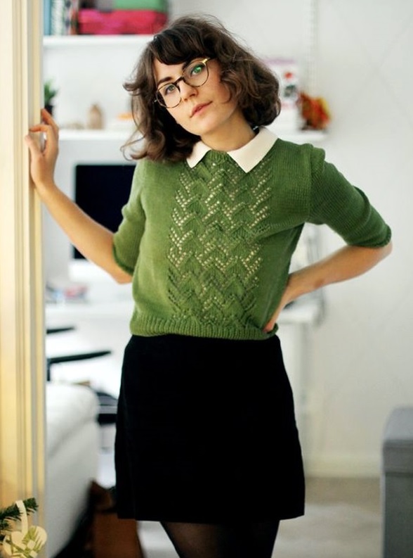 preppy look with a green sweater and a white shirt, a black mini skirt