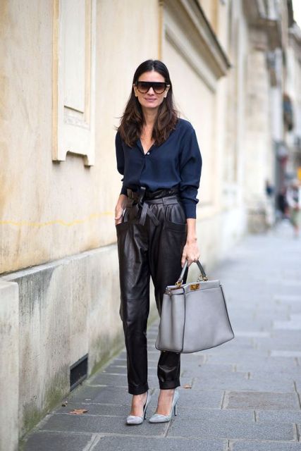 Leather pants outfit with dark blue shirt, light gray shoes and big bag