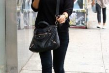 With black shirt, jeans and crossbody bag