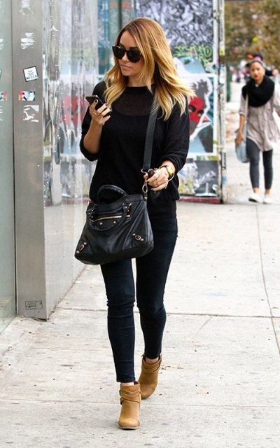 With black shirt, jeans and crossbody bag