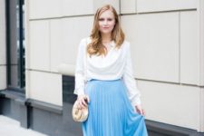 With blue pleated skirt, neutral sandals and mini bag