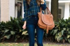 With plaid shirt, skinny jeans and brown bag