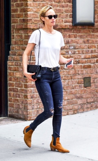 With white t-shirt, distressed jeans and bag with chain strap