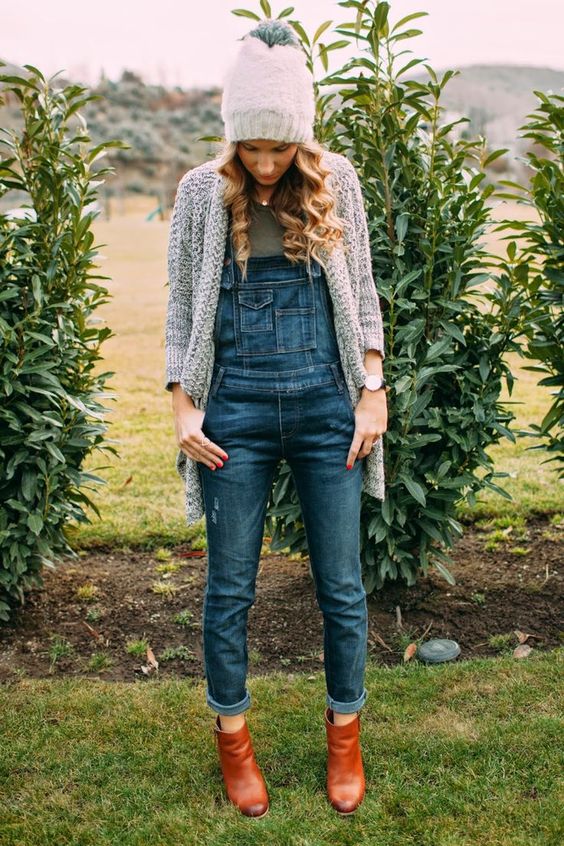 a denim overall, ankle boots and a warm grey cardigan