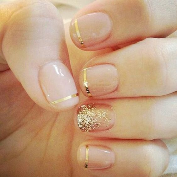 French mani with gold striped and a glitter accent nail