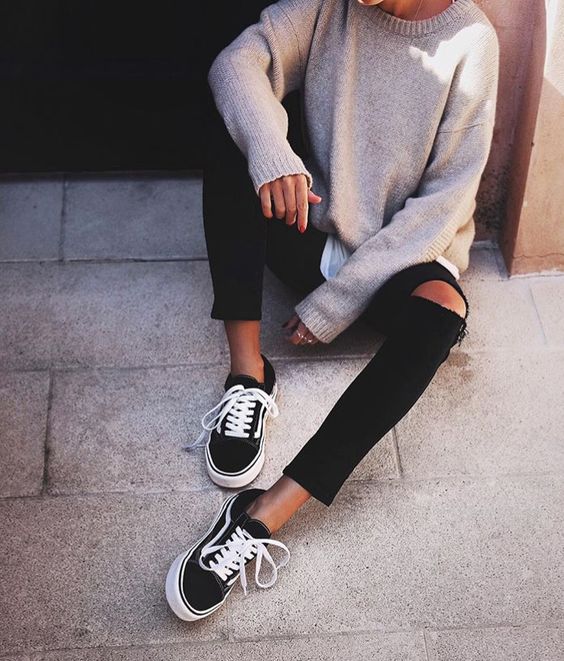 distressed black jeans, a neutral sweater and black chucks