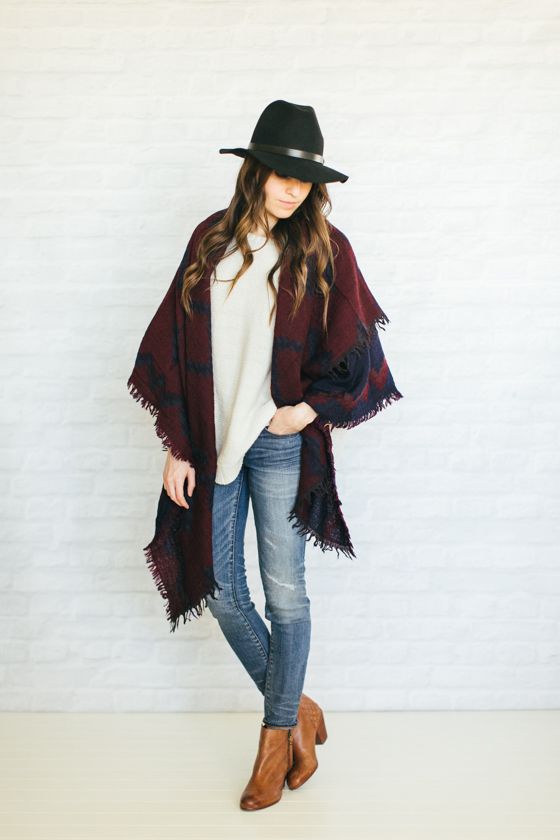 jeans, a white sweater, brown boots and a burgundy and black scarf