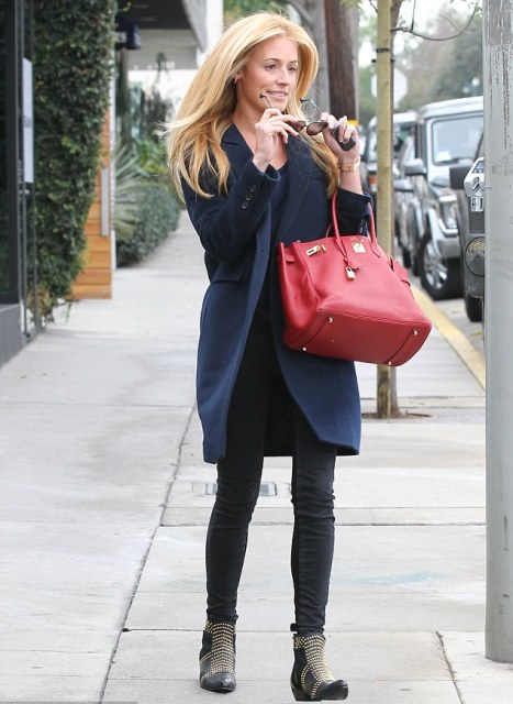 With black jeans, big red bag and embellished boots