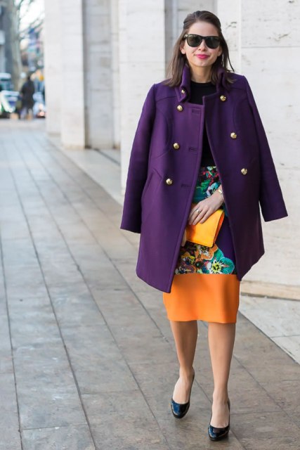 With black shirt, colorful printed knee length skirt and clutch