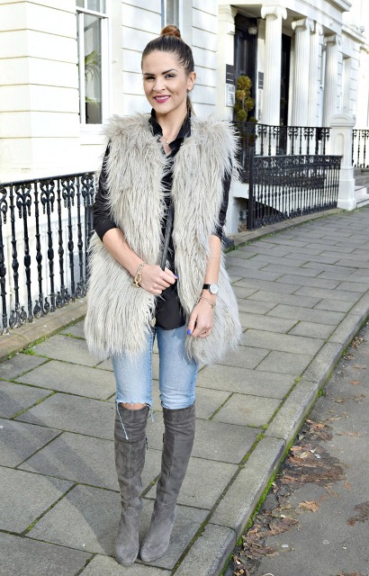 With black shirt, fur vest and jeans