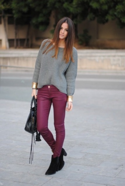 With gray loose sweater, black boots and leather bag