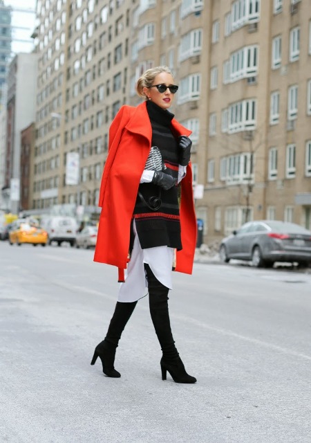 With white dress, oversized black sweater, over the knee boots and printed clutch