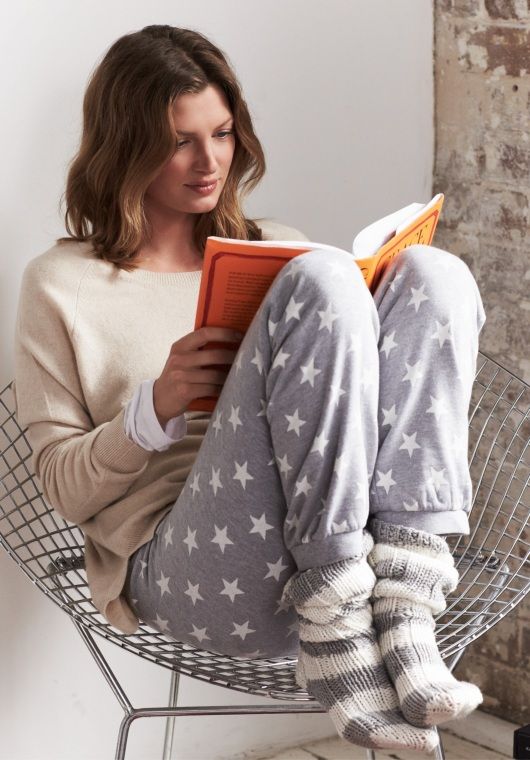 star-patterned trousers and a neutral sweatshirt, striped socks