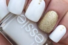 10 white nails with gold glitter dots and a gold accent nail