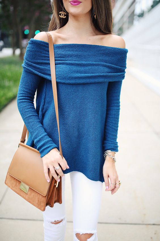white denim and a blue sweater with a tan bag