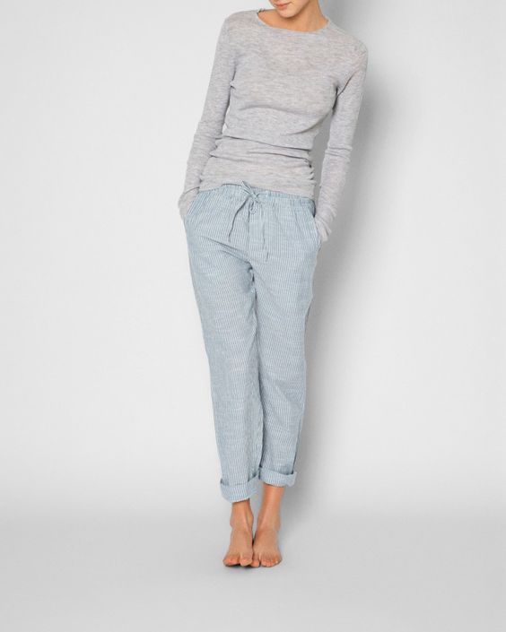striped blue pants and a light grey shirt with long sleeves