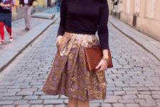 With black shirt, ankle boots and brown clutch
