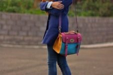 With blue coat, orange scarf, jeans and colorful bag
