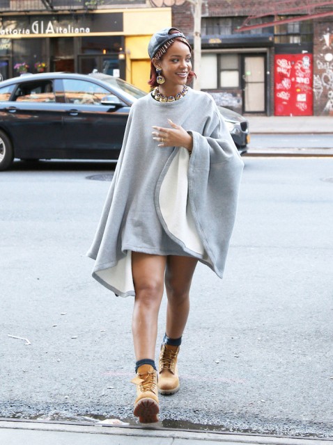 With gray poncho and statement necklace