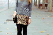 With gray shirt, black tights, pumps and chain strap bag