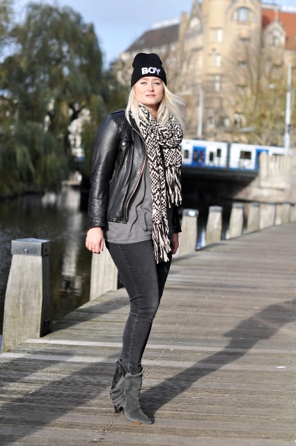 With gray shirt, jeans, leather jacket and printed scarf